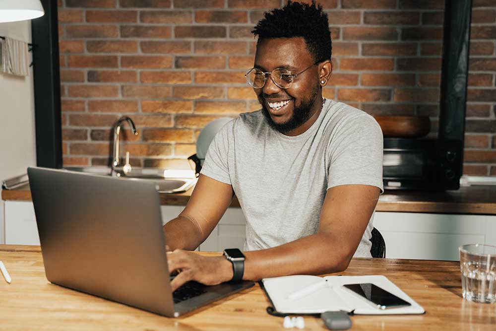 Smiling Man at laptop - Bator Pride - The Bator Blog